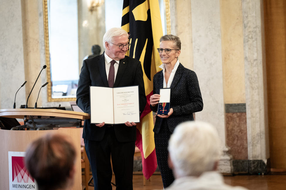 Bundespräsident Frank-Walter Steinmeier übergibt ein Verdienstkreuz am Bande an Anja Schneider aus Meiningen im Rahmen einer Ordensverleihung in Schloss Elisabethenburg